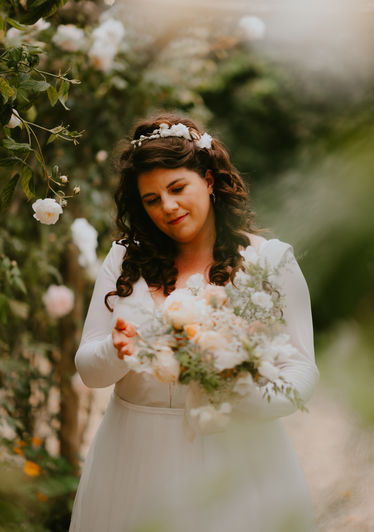 Romantic bridal portrait surrounded by colourful summer flowers and greenery